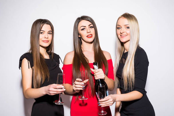 Three young women celebrating and drinking champagne on the party - Фото, зображення