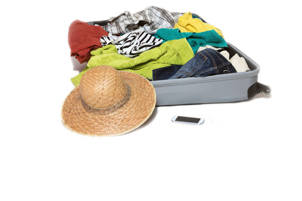 Captura de estudio de una maleta con ropa dispersa
 - Foto, imagen