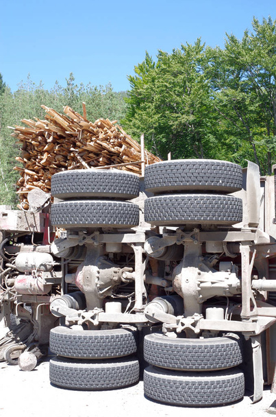 Umstürzender Lastwagen mit Brennholz zusammengestoßen  - Foto, Bild