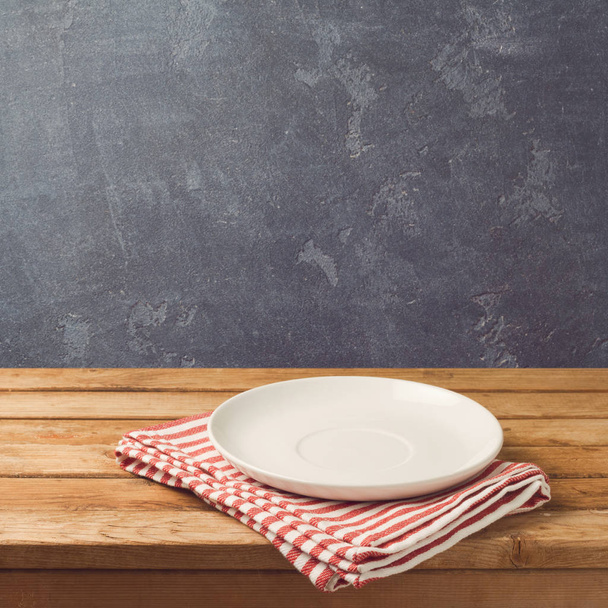 Empty white plate on wooden table - Фото, зображення