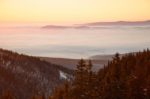 Pôr-do-sol dourado nas montanhas, um vasto nevoeiro sobre o vale
 - Foto, Imagem