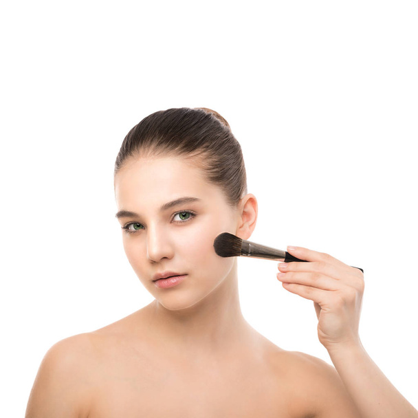 Young brunette woman with clean face. Girl perfect skin applying cosmetic brush. Isolated on a white. - Valokuva, kuva