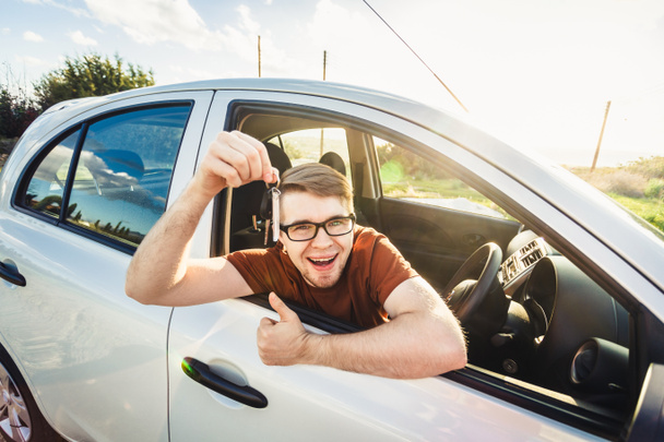 Attractive young happy man showing his new car keys and laughing - Photo, Image