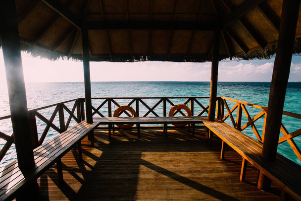 Wooden alcove at tropical island resort near open ocean - Φωτογραφία, εικόνα
