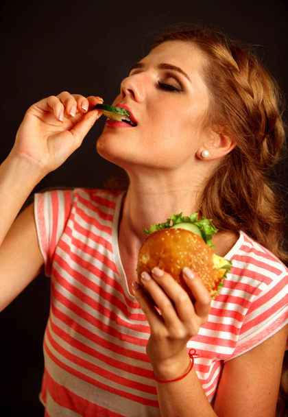 Девушка в экстазе наслаждается сэндвичем
. - Фото, изображение