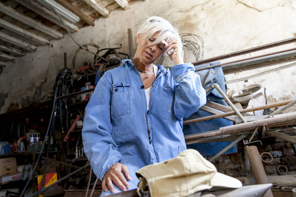 beautiful lady at work in his old workshop - 写真・画像