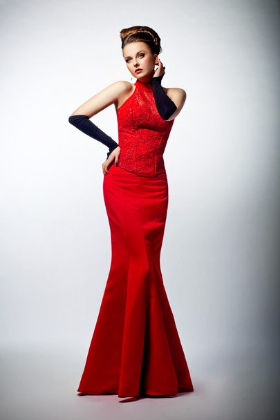 Tempting sexy slim female in sensual red long dress posing - Foto, imagen
