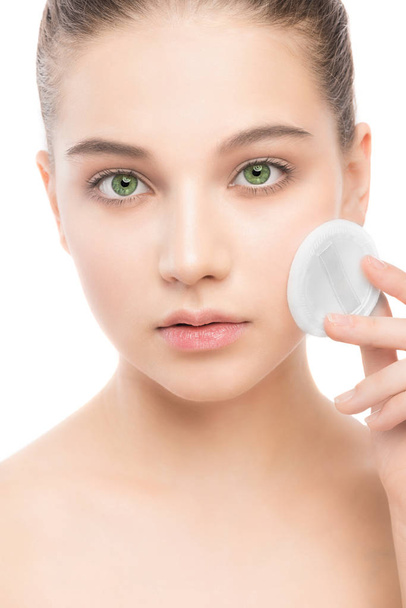 Young woman cares for face skin. Cleaning perfect fresh skin using cotton pad. Isolated. - Foto, imagen