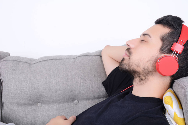 Man listening music on couch. - Fotó, kép