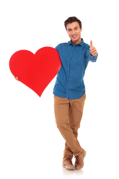 casual man holding big heart and making the ok sign - Фото, зображення