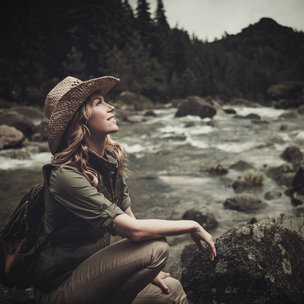 Όμορφη γυναίκα πεζοπόρος κοντά σε άγριο ορεινό ποτάμι. - Φωτογραφία, εικόνα