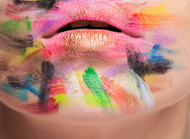 Lips in close up photo with colors on face - Foto, Bild
