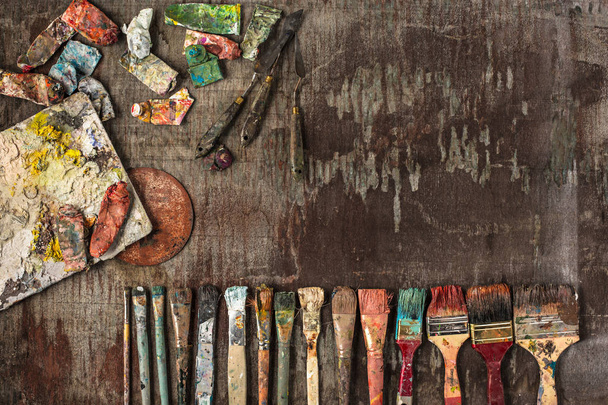 paint brushes and tubes of oil paints on wooden background - Foto, afbeelding