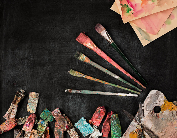 paint brushes and tubes of oil paints on wooden background - Fotografie, Obrázek