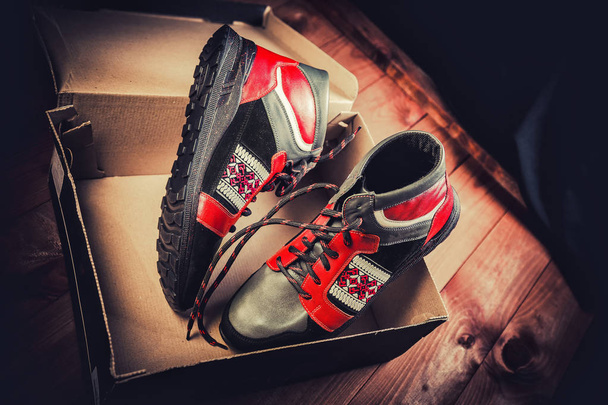 Red men's shoes on a wooden background - Fotoğraf, Görsel