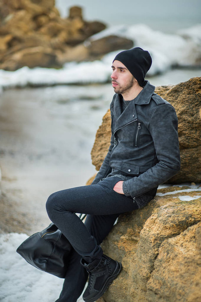 schöner junger Mann am Strand auf den Felsen - Foto, Bild