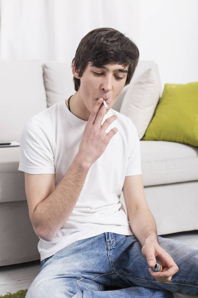 Young man smoking a cigarette - Fotoğraf, Görsel