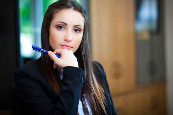 Young businesswoman holding pen - Fotó, kép