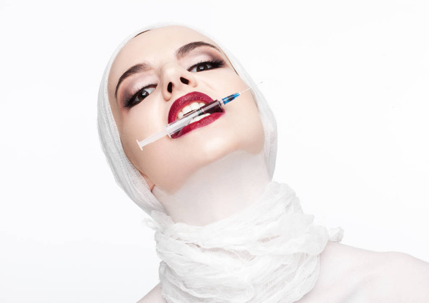 Beautiful model holding syringe in lips surgery - Fotografie, Obrázek