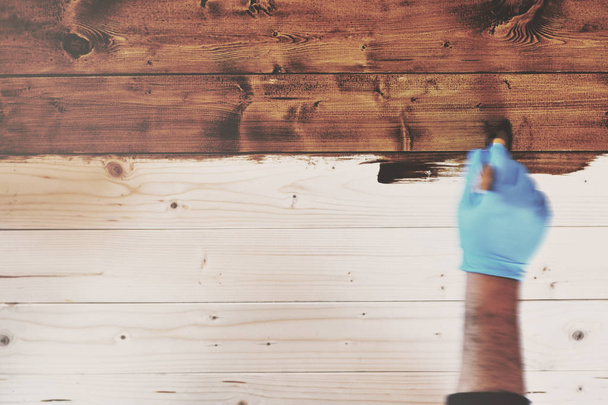 Hand In blauw handschoenen schilderen houten meubilair In Motion Blur stal - Foto, afbeelding