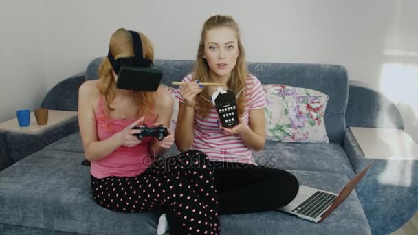 Two podurgi fun house. Playing in virtual reality helmet, eat food and watch television. Pajama party girlfriends - Filmati, video