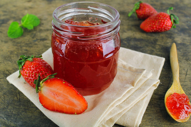 frische Erdbeermarmelade in Glasflasche mit Minzblatt - Foto, Bild