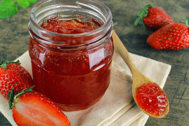 mermelada de fresa fresca en botella de vidrio con hoja de menta
 - Foto, imagen