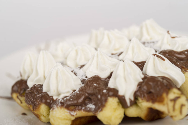 close-up shot of delicious Belgian waffle with chocolate topping and whipped cream - Foto, Imagem