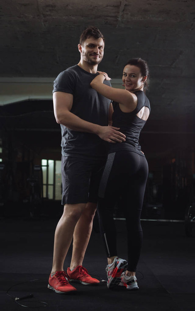 Young couple of man and woman hugging at the gym  - Foto, Imagen