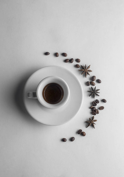 cup of coffee with anise and coffee beans on white - Photo, image
