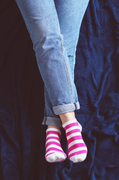 female legs in jeans and striped socks  - 写真・画像