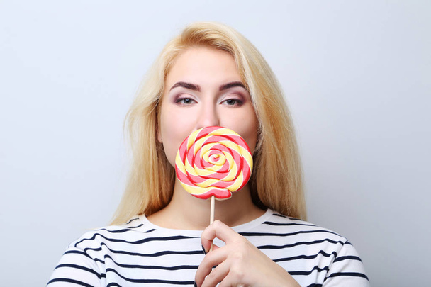 Young woman holding lollipop - Φωτογραφία, εικόνα