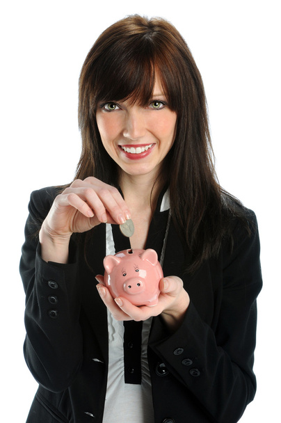 Woman Depositing Coin in Piggy Bank - 写真・画像