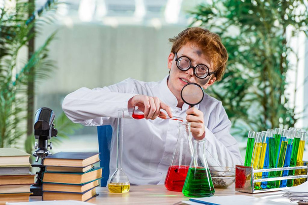 A laborban dolgozó fiatal őrült kémikus - Fotó, kép