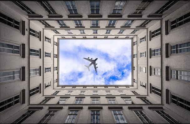 Avion jet passant sur cluod ciel dans une ville
 - Photo, image