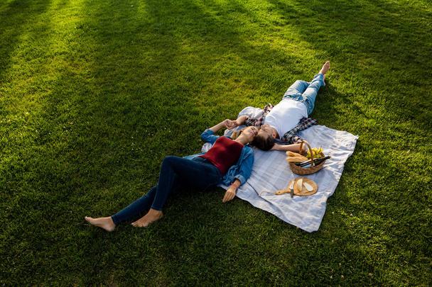 couple relaxing in park after picnic - Foto, afbeelding