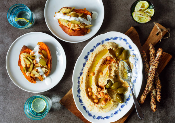 gesunder hausgemachter cremiger Hummus mit Olivenöl und Semmelspießen - Foto, Bild