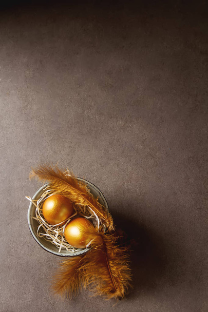 Holiday decoration. Easter eggs are golden in color. Simple gray - Foto, afbeelding