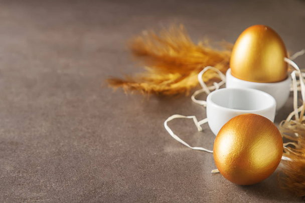 Holiday decoration. Easter eggs are golden in color. Simple gray - Foto, imagen