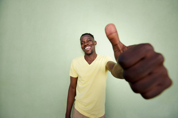 african man gesturing sign by green wall - Photo, Image