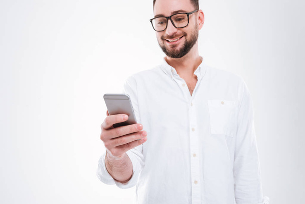 Handsome happy young bearded man chatting by phone - 写真・画像