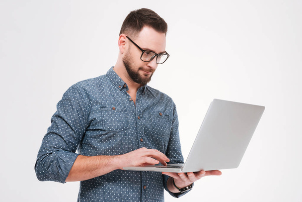 Concentrated young bearded man using laptop - Foto, immagini
