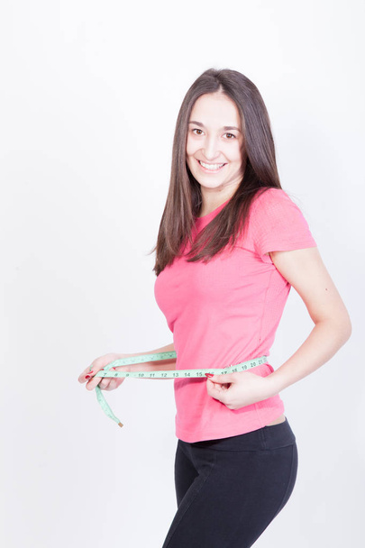 Sportos vékony nő, mérési derekát intézkedés szalag után diéta alatt fehér háttér - Fotó, kép
