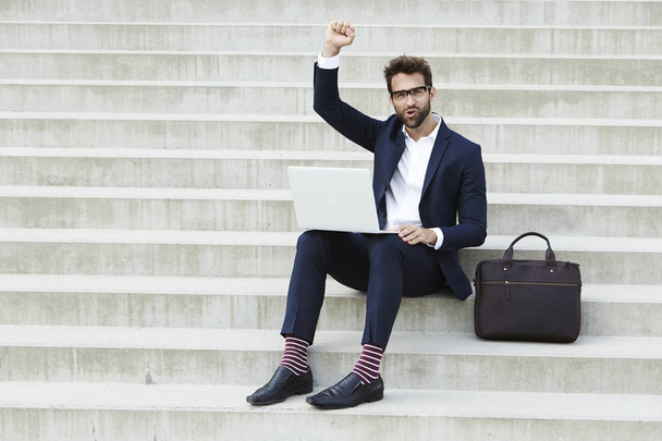 Businessman with laptop cheering  - Photo, image