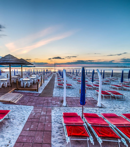 椅子と、夕焼けの海で青いパラソル - 写真・画像