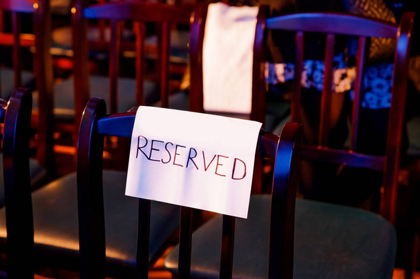 One wooden theater seat with the handwritten reserved sign - Photo, Image