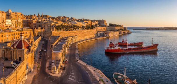 La Valeta, Malta - Vista del horizonte de La Valeta y el Gran Puerto con hermosa salida del sol, barcos y cielo azul claro
 - Foto, Imagen