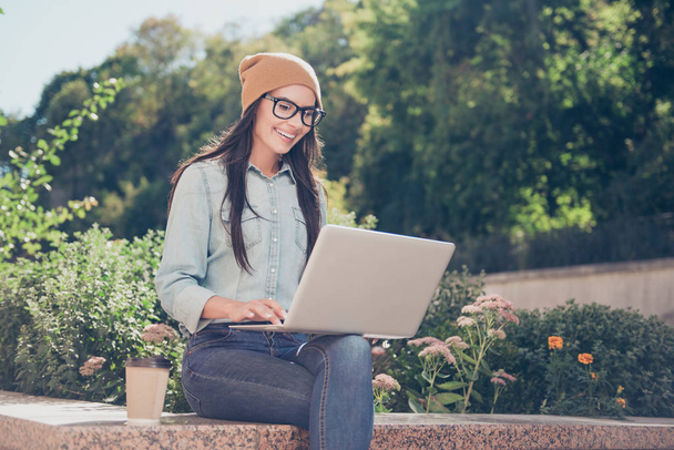 Happy hipster young woman working on laptop in the park - Foto, imagen