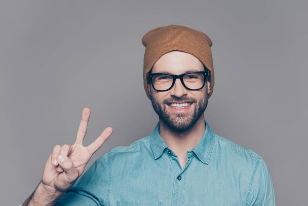 Handsome cheerful man  in hat and glasses showing v-sign - Φωτογραφία, εικόνα