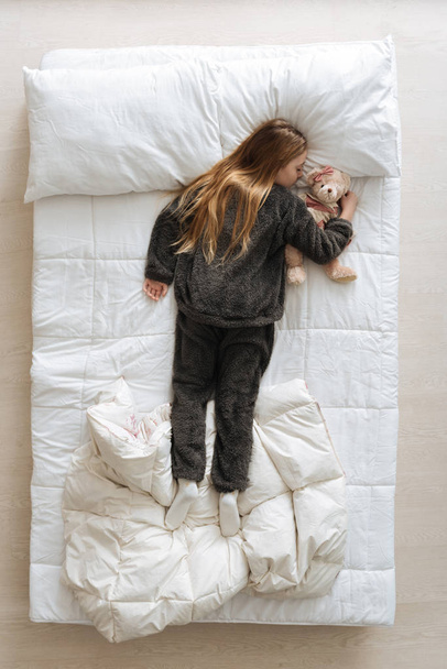 ребенок держит своего плюшевого мишку близко
 - Фото, изображение